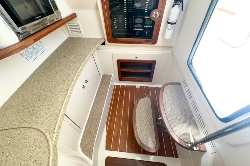 Slide: The Image of 2015 Grady-White Freedom 375 interior with kitchenette, seating, and control panel. - 46