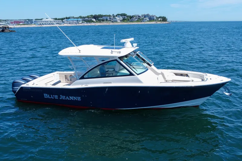 Slide: The Image of 2015 Grady-White Freedom 375 boat on open water, near coastal town. - 51