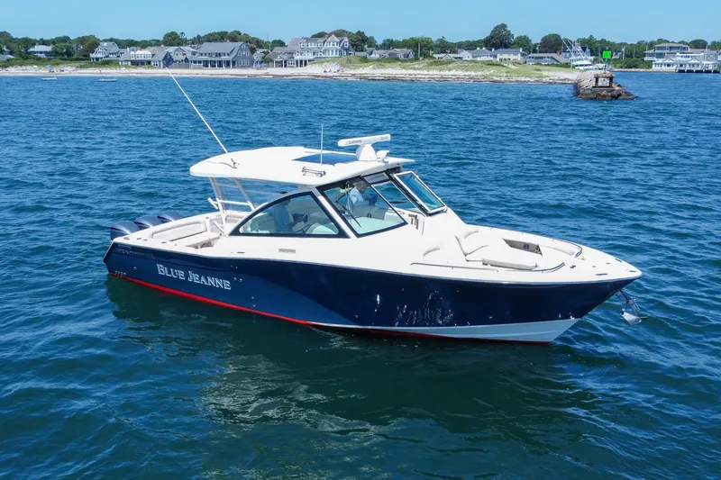 Slide: The Image of 2015 Grady-White Freedom 375 boat on blue ocean near coastal homes. - 12