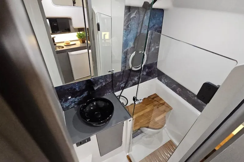 Slide: The Image of Modern bathroom in 2026 Hanover 327 RV with sleek black sink and wooden accents. - 10