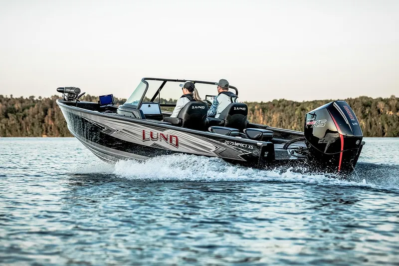 Slide: The Image of Manufacturer Provided Image: Manufacturer Provided Image: 2025 Lund 2025 Impact XS Sport boat cruising on a lake with two passengers. - 1