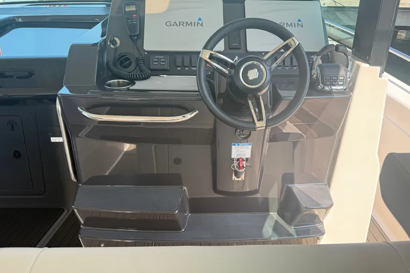 Slide: The Image of 2016 Tiara Yachts Q44 helm with Garmin navigation system and sleek steering wheel. - 17