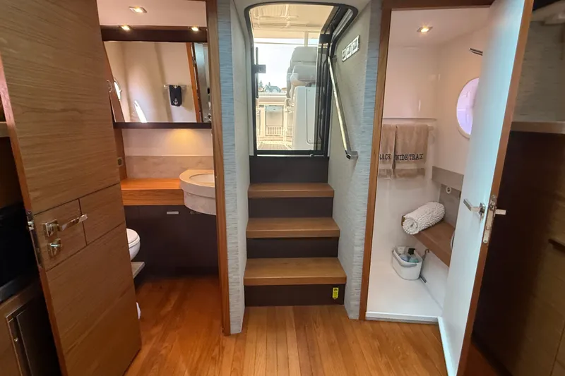 Slide: The Image of 2016 Tiara Yachts Q44 interior with wooden flooring, stairs, and bathroom amenities. - 33