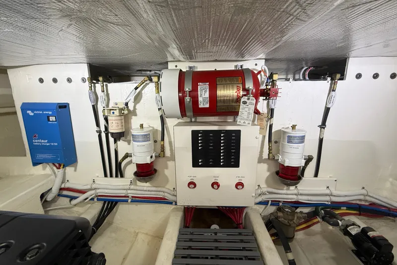 Slide: The Image of Engine room of 2016 Tiara Yachts Q44, featuring fire suppression system and battery charger. - 64