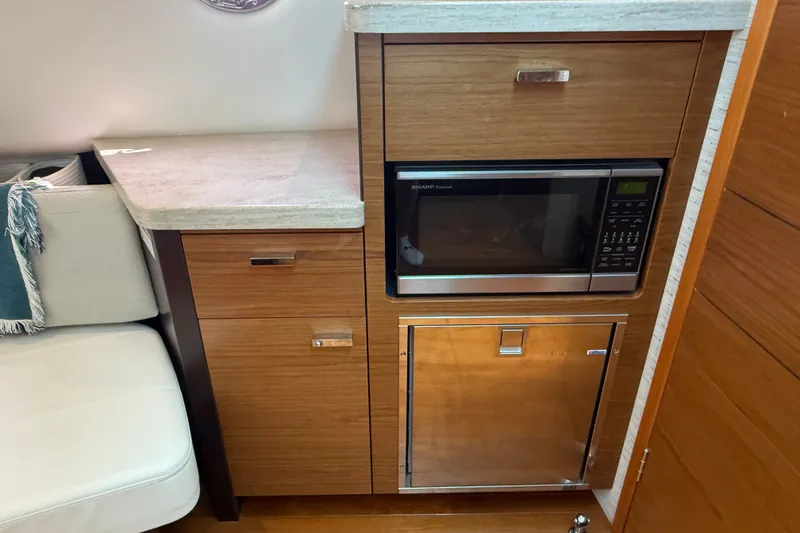 Slide: The Image of 2016 Tiara Yachts Q44 interior with microwave and cabinetry in compact kitchen area. - 26