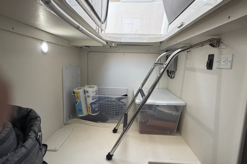 Slide: The Image of 2016 Tiara Yachts Q44 interior storage area with ladder and organized supplies. - 42
