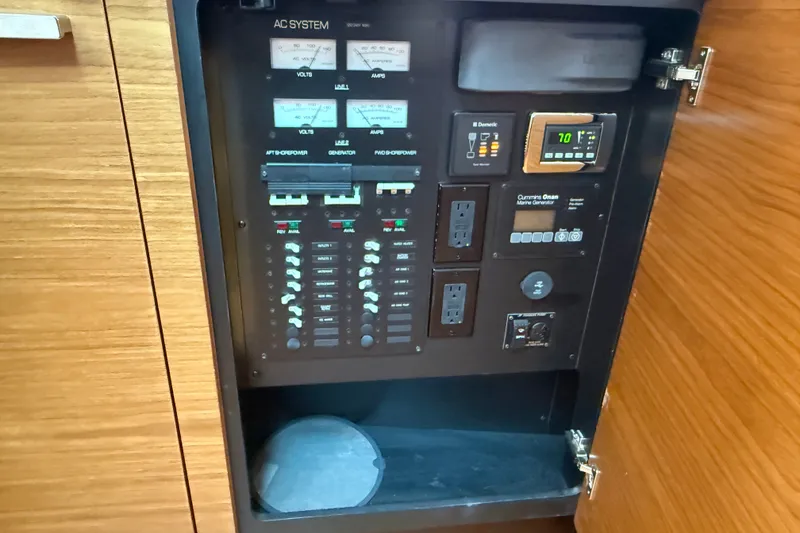 Slide: The Image of Electrical control panel on a 2016 Tiara Yachts Q44, featuring various switches and gauges. - 28