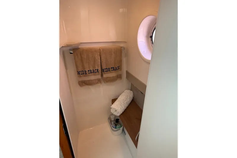Slide: The Image of 2016 Tiara Yachts Q44 bathroom with towels and porthole window. - 31