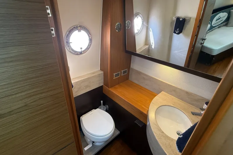 Slide: The Image of 2016 Tiara Yachts Q44 bathroom with sink, toilet, and porthole window. - 35