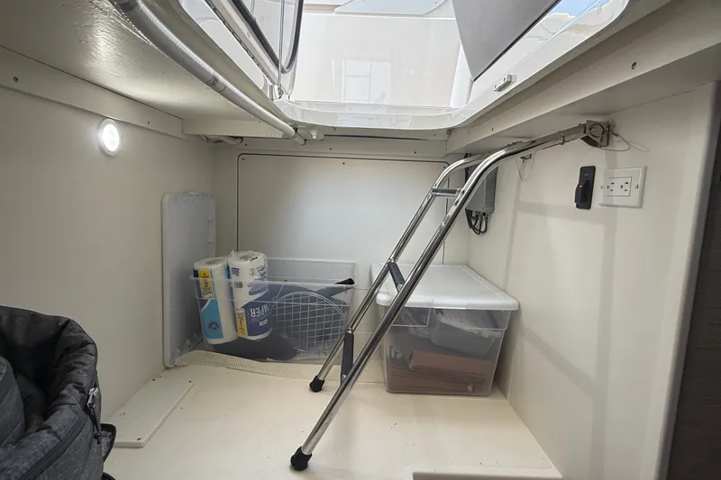 Slide: The Image of Interior storage space of a 2016 Tiara Yachts Q44, featuring ladder and supplies. - 45