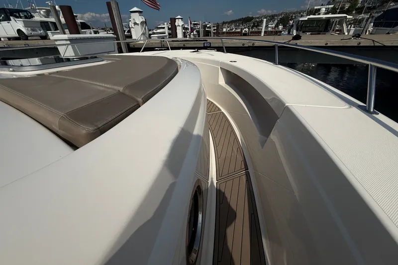 Slide: The Image of 2016 Tiara Yachts Q44 deck view at marina, showcasing sleek design and seating area. - 48