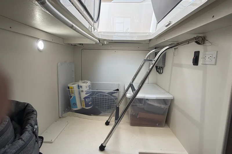 Slide: The Image of 2016 Tiara Yachts Q44 interior storage area with ladder and supplies. - 43