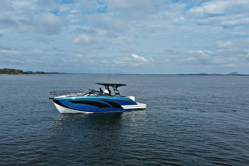 Slide: The Image of 2026 Hanover 327 boat cruising on a calm lake under a cloudy sky. - 0