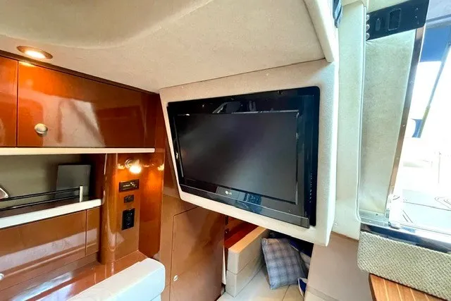 Slide: The Image of 2008 Sea Ray Sundancer 330 interior with mounted TV and wooden cabinetry. - 24