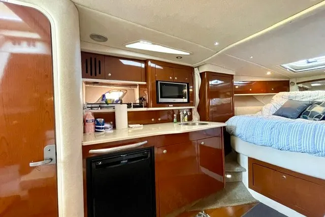 Slide: The Image of 2008 Sea Ray Sundancer 330 interior with kitchenette, microwave, and cozy sleeping area. - 18