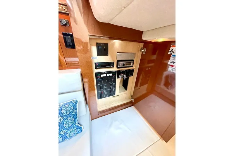 Slide: The Image of 2008 Sea Ray Sundancer 330 interior control panel with wood finish and seating area. - 25