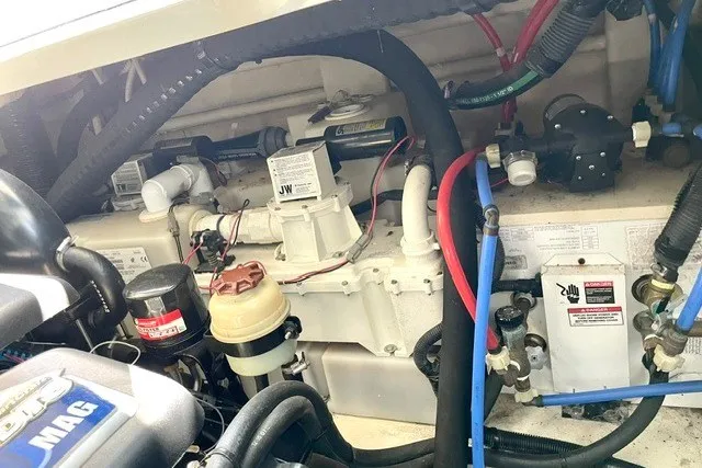 Slide: The Image of Engine compartment of a 2008 Sea Ray Sundancer 330, showcasing mechanical components and wiring. - 34