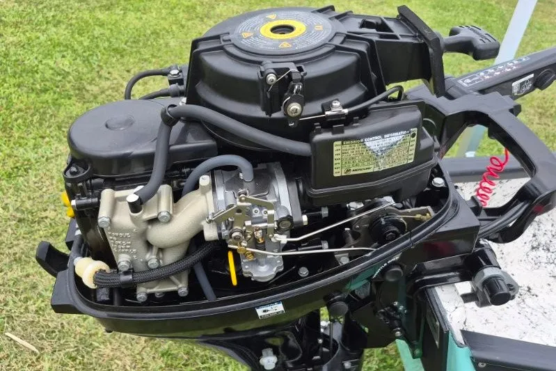 Slide: The Image of 2022 Gheenoe NMZ 15.4 outboard motor, detailed view on grassy background. - 15