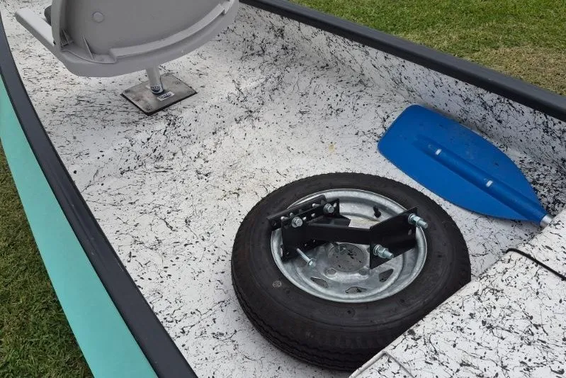 Slide: The Image of 2022 Gheenoe NMZ 15.4 interior with seat, spare tire, and blue paddle. - 10