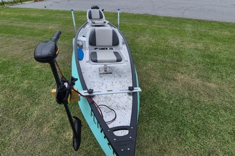 Slide: The Image of 2022 Gheenoe NMZ 15.4 boat with motor on grassy area, featuring two seats. - 7