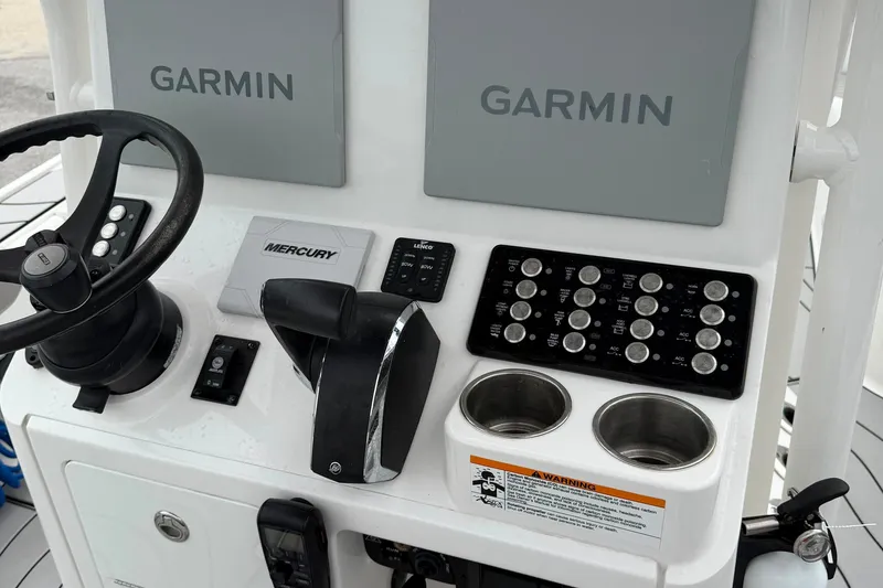 Slide: The Image of 2023 Caymas 26 HB boat console with Garmin displays and Mercury controls. - 10