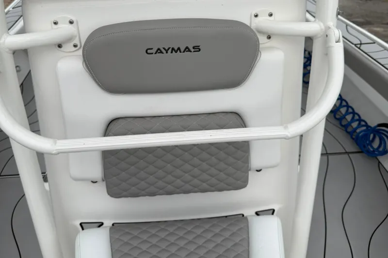 Slide: The Image of 2023 Caymas 26 HB boat seat with gray quilted cushions and white frame. - 16