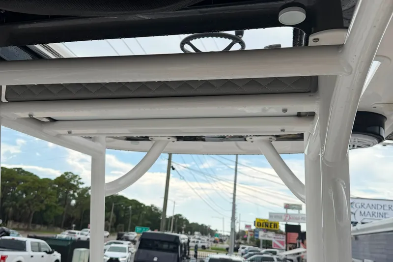 Slide: The Image of 2023 Caymas 26 HB boat's T-top structure with street view background. - 9