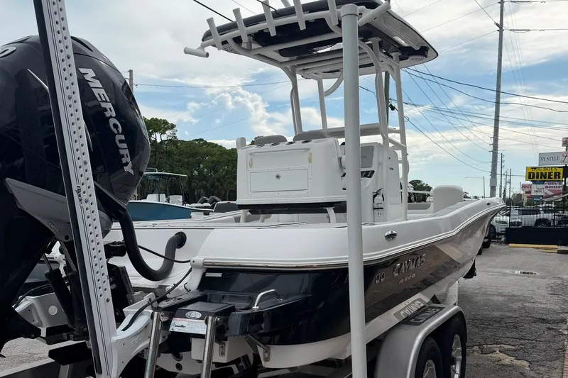 Slide: The Image of 2023 Caymas 26 HB boat with Mercury engine, parked on a trailer in a marina. - 3