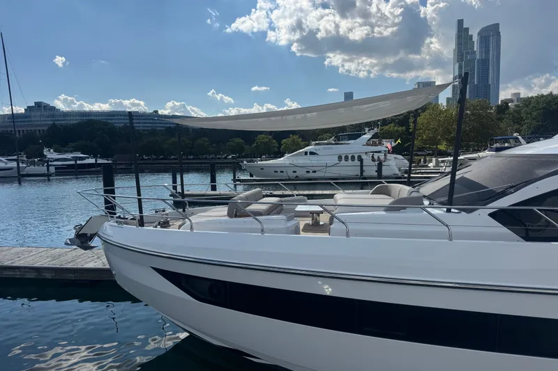 Slide: The Image of 2023 Azimut Fly 68 yacht docked at a marina with city skyline backdrop. - 184