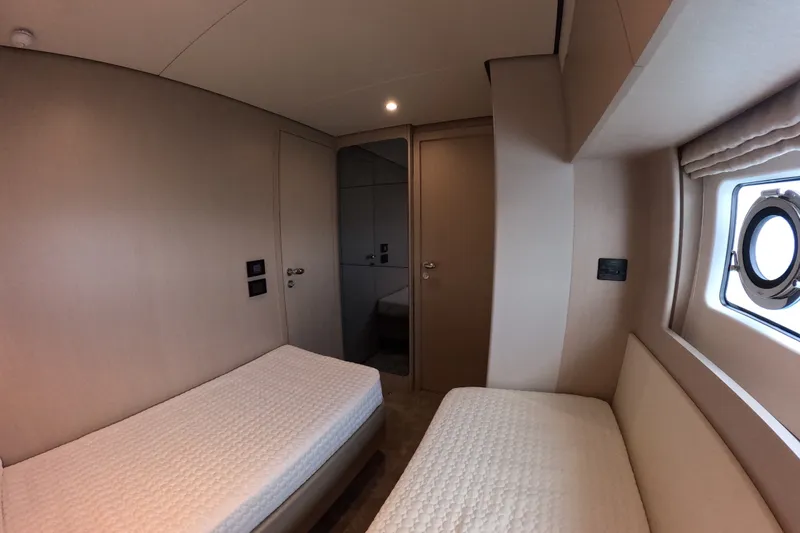 Slide: The Image of Interior cabin of 2023 Azimut Fly 68 yacht with twin beds and porthole window. - 98