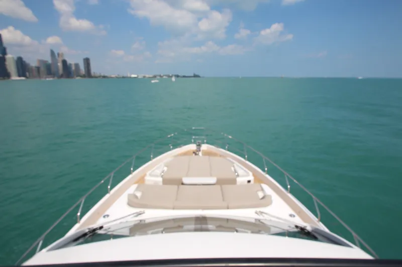Slide: The Image of 2023 Azimut Fly 68 yacht cruising on a clear blue sea near a city skyline. - 27