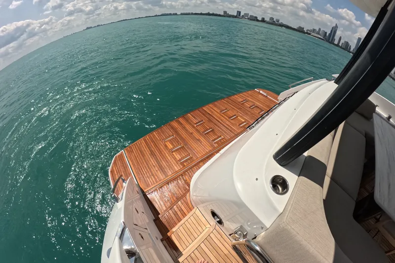 Slide: The Image of 2023 Azimut Fly 68 yacht with teak deck, overlooking ocean and city skyline. - 20