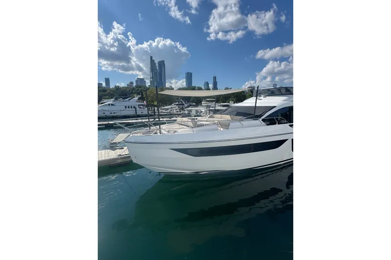 Slide: The Image of 2023 Azimut Fly 68 yacht docked in marina with city skyline backdrop. - 175