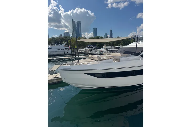 Slide: The Image of 2023 Azimut Fly 68 yacht docked in a marina with city skyline backdrop. - 176