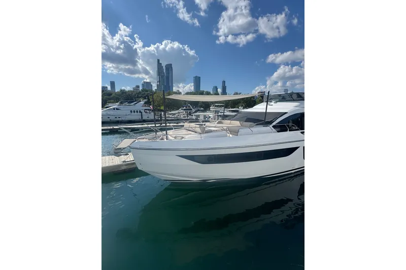 Slide: The Image of 2023 Azimut Fly 68 yacht docked in a marina with city skyline backdrop. - 174