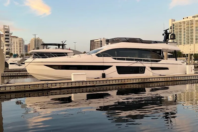 Slide: The Image of 2023 Azimut Fly 68 yacht docked at a marina, reflecting on calm water. - 123