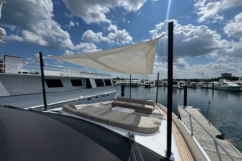 Slide: The Image of Luxurious 2023 Azimut Fly 68 yacht with sunshade, docked at a marina under a cloudy sky. - 170