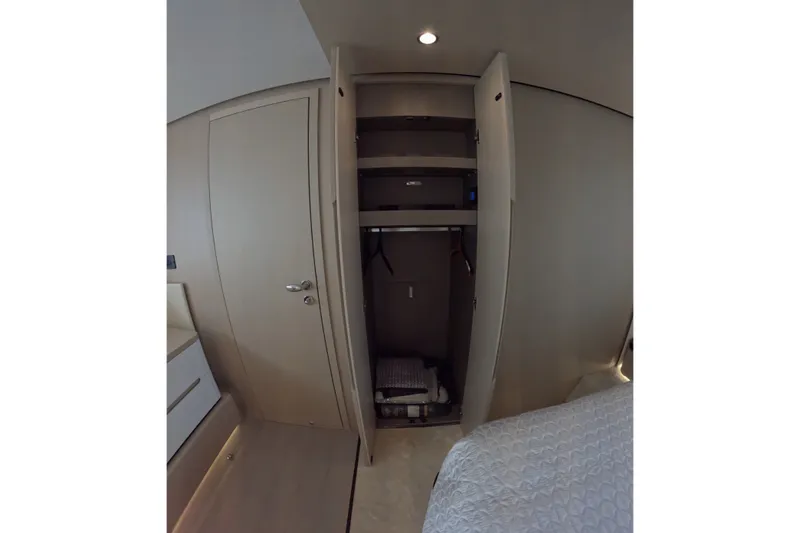 Slide: The Image of Interior of 2023 Azimut Fly 68 yacht showing open closet with shelves and hangers. - 87