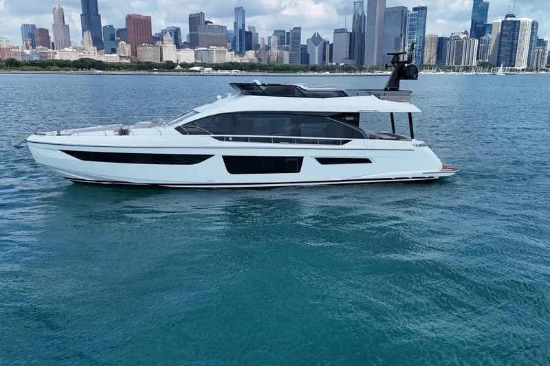 Slide: The Image of 2023 Azimut Fly 68 yacht cruising on blue water with city skyline backdrop. - 7