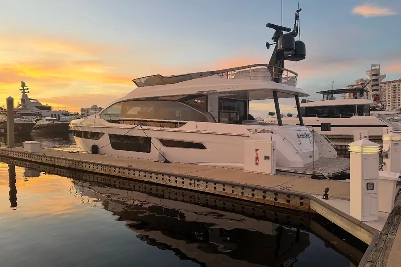 Slide: The Image of 2023 Azimut Fly 68 yacht docked at sunset, reflecting on calm water. - 126