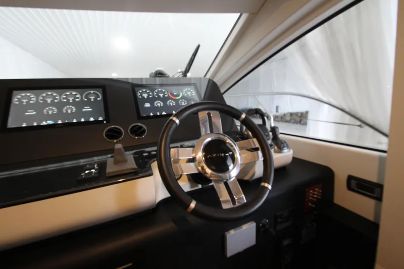 Slide: The Image of 2023 Azimut Fly 68 yacht helm with modern controls and sleek steering wheel design. - 68
