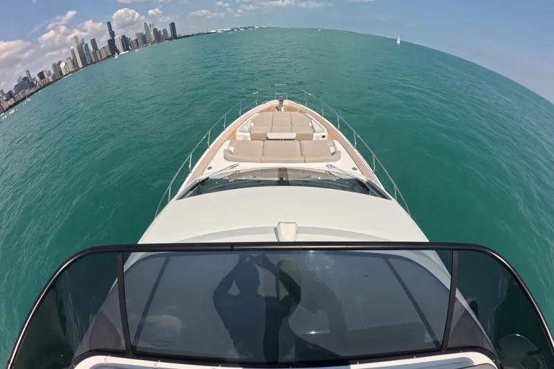 Slide: The Image of Azimut Fly 68 yacht cruising on turquoise waters, city skyline in background, 2023 model. - 26
