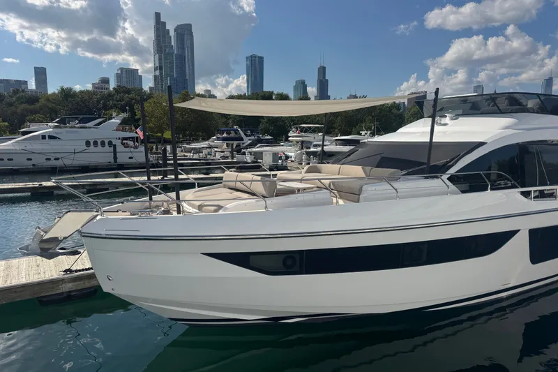 Slide: The Image of 2023 Azimut Fly 68 yacht docked in a marina with city skyline backdrop. - 181