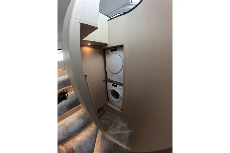 Slide: The Image of Laundry area inside 2023 Azimut Fly 68 yacht, featuring stacked washer and dryer. - 74