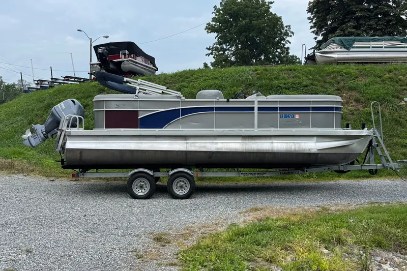 The Image of 2020 Bennington S 22 SL pontoon boat on trailer, parked on gravel. - 3