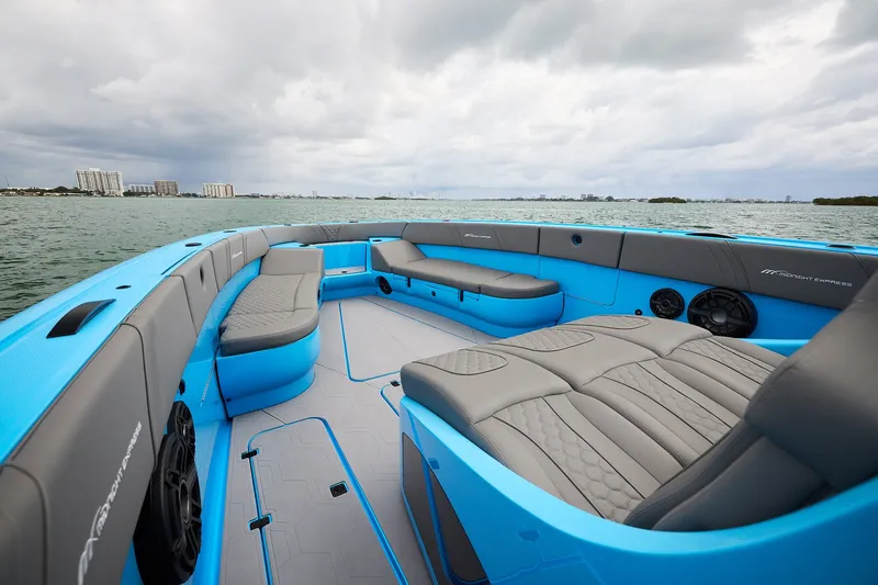 Slide: The Image of Luxurious Midnight Express 43 Open boat interior with gray seating and blue accents on a cloudy day. - 11