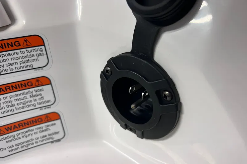Slide: The Image of 2024 Tahoe 200 S boat warning labels and power socket detail. - 37
