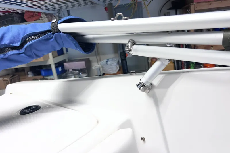 Slide: The Image of 2024 Tahoe 200 S boat detail with blue canopy and metal frame in storage. - 21