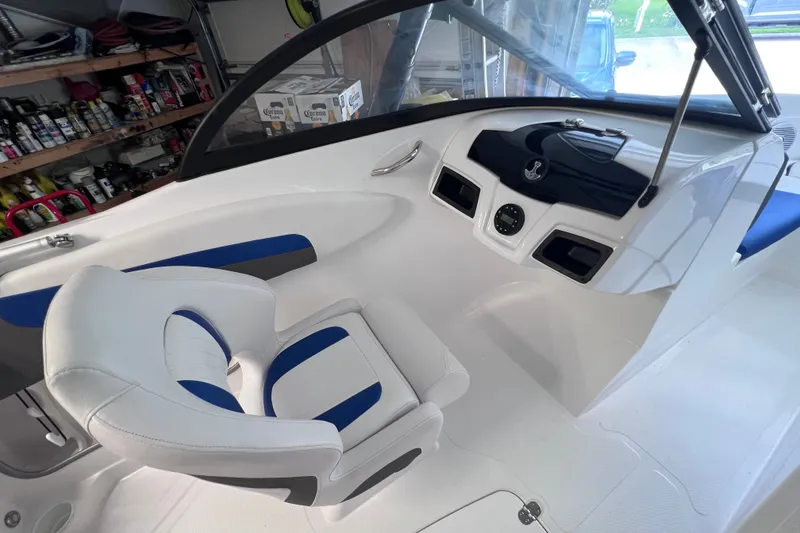 Slide: The Image of 2024 Tahoe 200 S boat interior with white and blue seating, sleek dashboard design. - 24