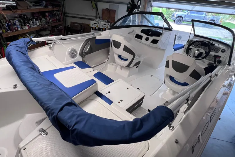 Slide: The Image of 2024 Tahoe 200 S boat interior with blue and white seating in a garage setting. - 13
